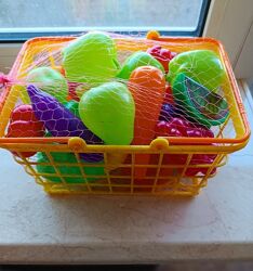 Пластиковые игрушечные овощи и фрукты в удобной корзине.